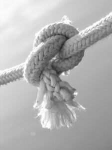 Black and white close-up of a knotted rope showcasing texture and twist.